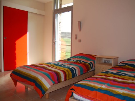 Colourful picture of one of the rooms with two beds