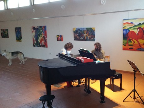 Salle multimédia avec peintures et piano à queue Yamaha